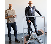 Wissenschaftler Martin Matke demonstriert eine Übung auf einem Balance-Brett im Rahmen der Studie